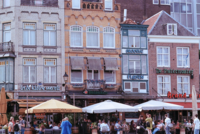 Lively European Street Scene Historic European buildings, outdoor cafes with people enjoying drinks and meals.