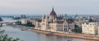 Hungarian Parliament by the Danube Panoramic view of the ornate Hungarian Parliament Building next to the Danube River, with city skyline in Budapest.