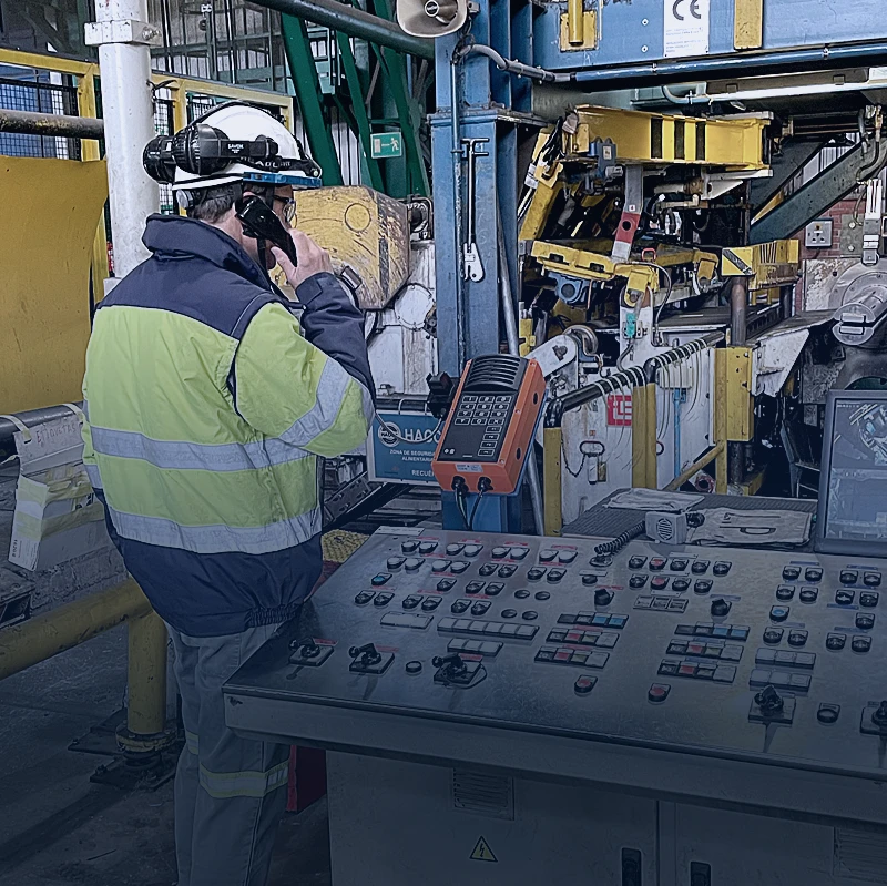 Effective communication in manufacturing environments Worker using industrial intercom for reliable communication in manufacturing facility